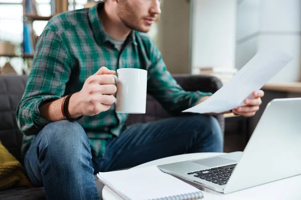 Imagen recortada del hombre con té junto a la mesa — Foto de Stock