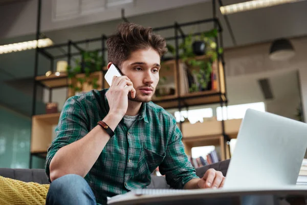 Ember, beszélünk a telefon, a kanapé — Stock Fotó