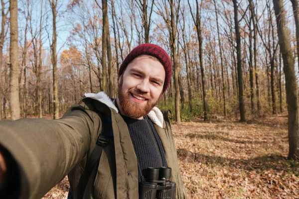 Junger bärtiger Mann macht Selfie im Wald. — Stockfoto