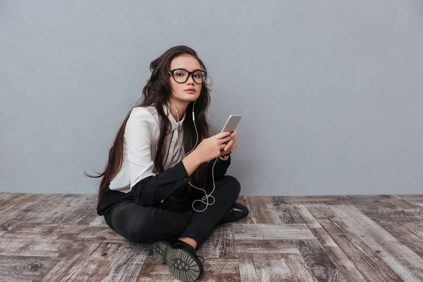 Aziatische vrouw zittend op de vloer met telefoon — Stockfoto