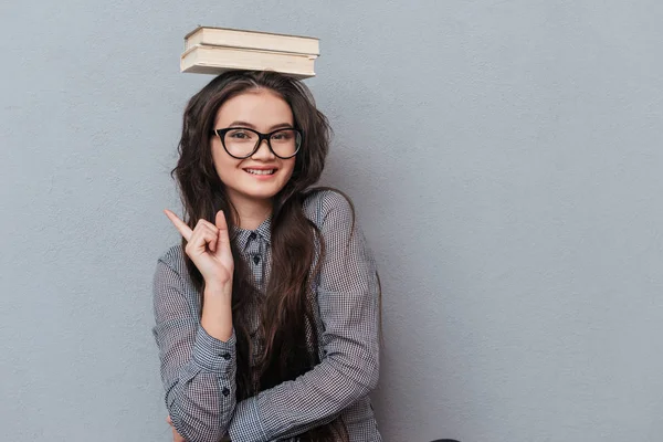 Joven mujer asiática con libros en la cabeza —  Fotos de Stock