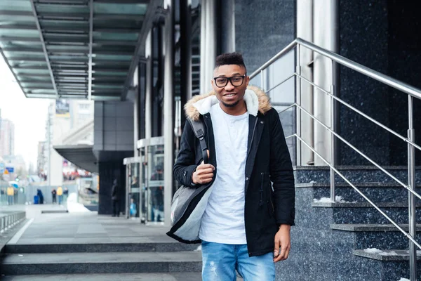 Young african man wearing backpack walking on the street