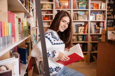 Gülümseyen öğrenci kitaplık Kitaplığı'adlı bir kitap okuma