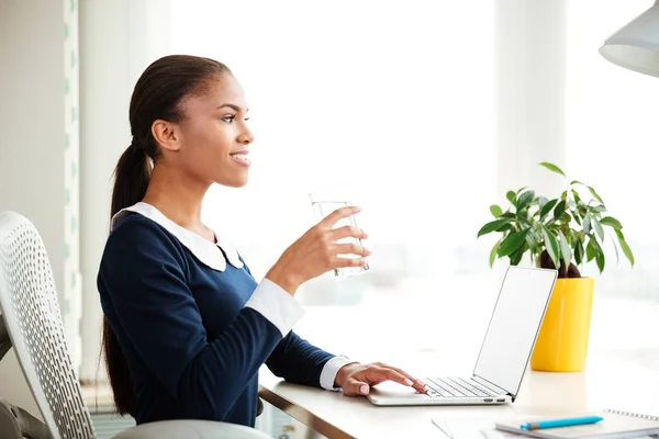 Mujer de negocios africana con agua en la oficina — Foto de Stock