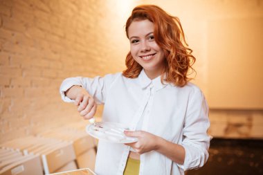 Çekici Kızıl saçlı kadın ressam yağlıboya ve palet ile