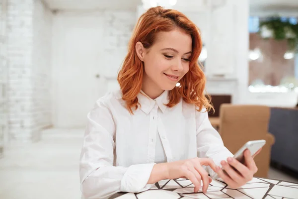 Joyeux rousse jeune femme bavarder par téléphone dans le café — Photo