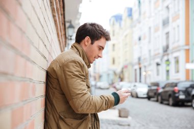 Yakışıklı genç adam sokakta yürürken ve sohbet