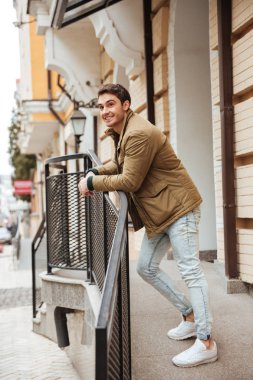 Neşeli genç adam sokakta yürürken ve bir kenara arıyorsunuz.