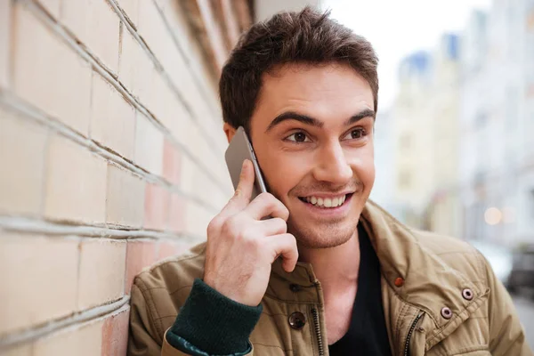 Joven feliz en la calle hablando por su teléfono . — Foto de Stock