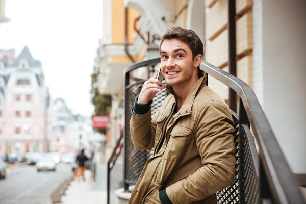 Hombre alegre caminando por la calle y hablando por teléfono . — Foto de Stock