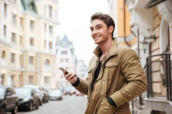 Knappe vrolijke man lopen op straat en chatten — Stockfoto