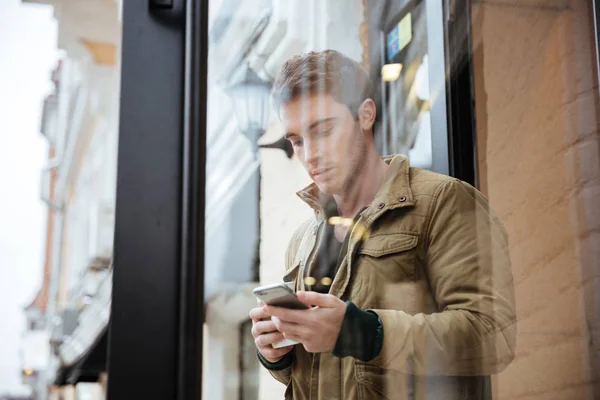 Jonge man lopen en chatten zijn telefonisch — Stockfoto