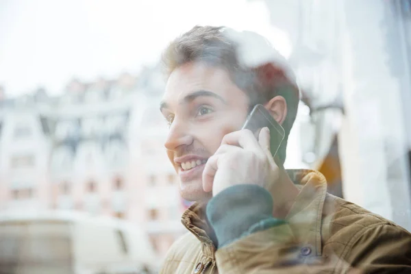 Vrolijke man op de straat lopen en praten via de telefoon. — Stockfoto