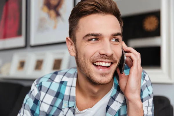 Lachen bristle man praten door zijn telefoon binnenshuis — Stockfoto