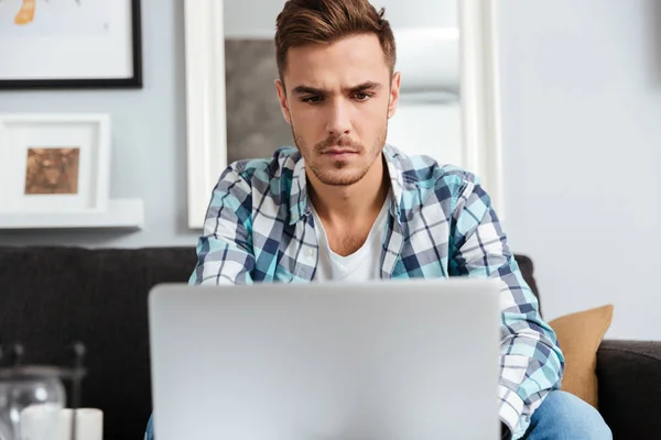 Hombre de cerdas concentradas usando computadora portátil — Foto de Stock