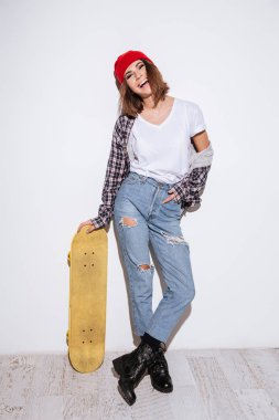 Genç kadın kaykay holding beyaz arka plan üzerinde izole