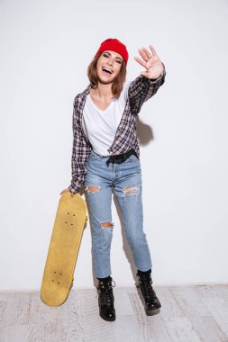 Kaykay holding beyaz arka plan üzerinde izole kadın