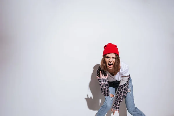 Donna vestita in camicia in gabbia stampa fare gesto rock — Foto Stock