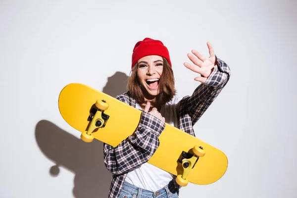 Veselá žena hospodářství skateboard — Stock fotografie