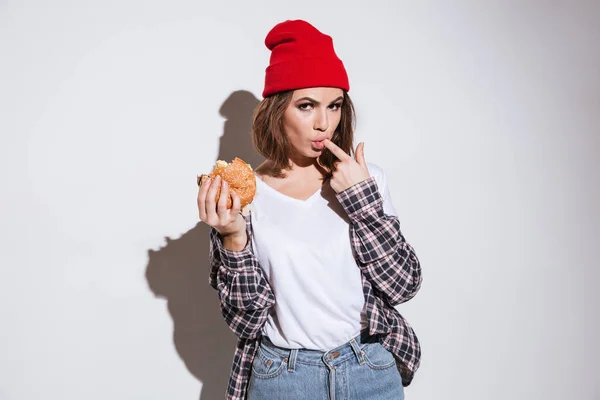 Jeune femme affamée manger hamburger — Photo