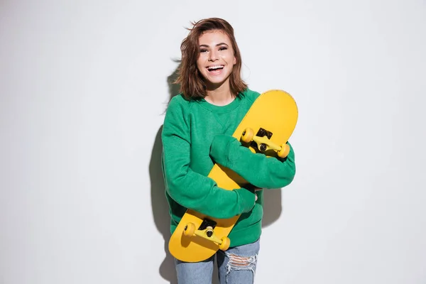 Χαμογελώντας σκέιτερ γυναίκα με skateboard. — Φωτογραφία Αρχείου