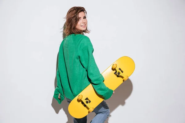 Schöne Skaterin mit Skateboard. — Stockfoto