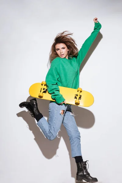 Skater mulher pulando sobre fundo branco . — Fotografia de Stock