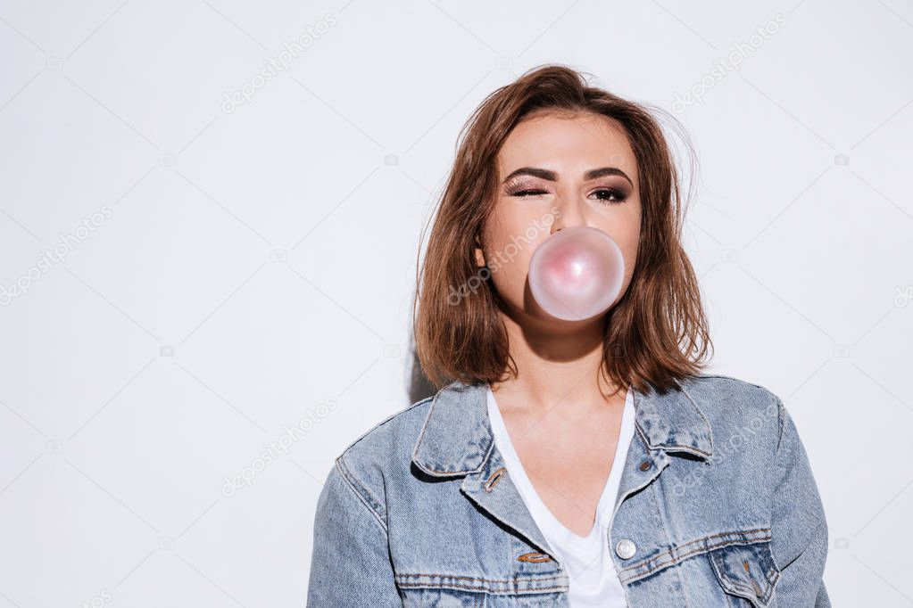 Playful lady blowing bubble with chewing gum.