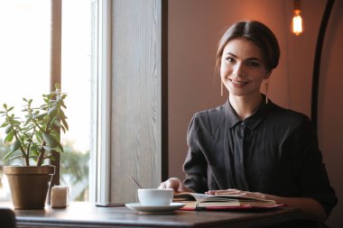 Neşeli genç bayan okuma kitabı Cafe