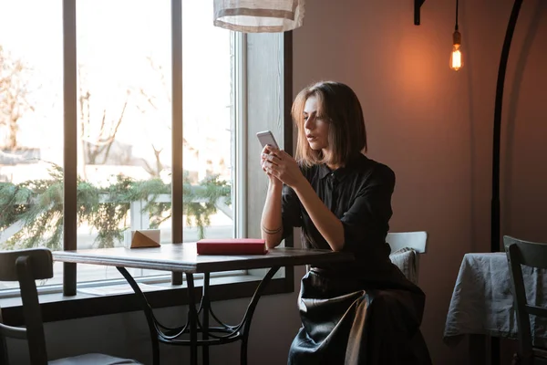 Bardzo młoda dama, siedząc przy stoliku w kawiarni i na czacie — Zdjęcie stockowe