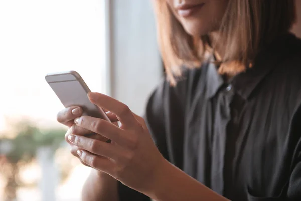 Oříznutí obrazu pomocí mobilních telefonů mladé ženy. — Stock fotografie