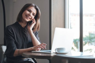 Telefonla konuşurken kafede masada oturan güzel Bayan.