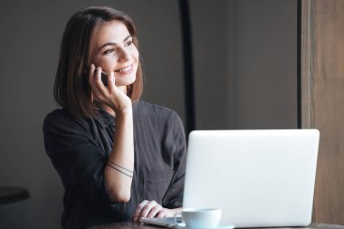 Çekici kadın telefonla konuşuyor masada oturuyordu