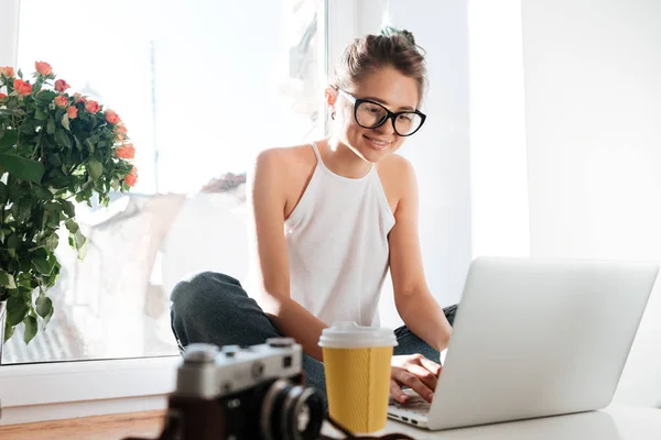 Cheerful woman photographer in glasses working with laptop at home — Stock Photo, Image