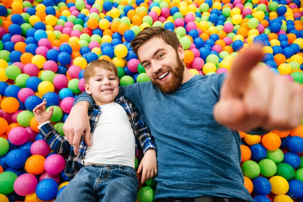 Junge und sein Vater spielen am Pool mit bunten Bällen — Stockfoto