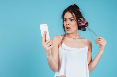 Telefon kullanarak saç curlers ile karışık genç bayan