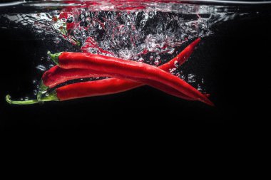 Kırmızı biber düşen izole suya