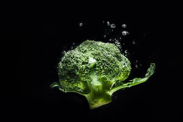 Свежий зеленый брокколи упал в воду — стоковое фото