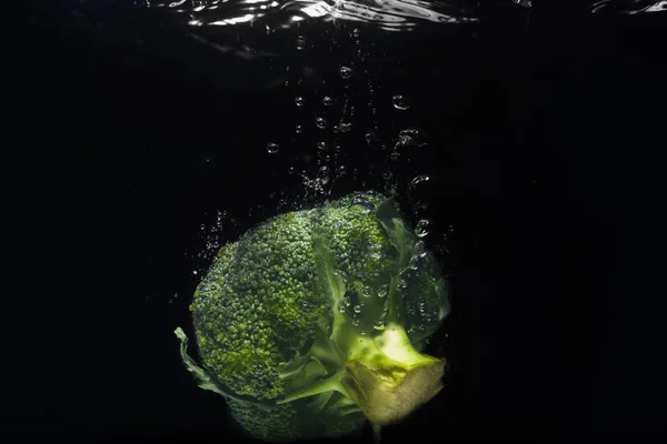 Свежий зеленый брокколи упал в воду изолированы — стоковое фото