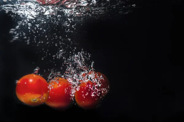 Fotografia ad alta velocità schizzo di pomodoro in acqua — Foto Stock