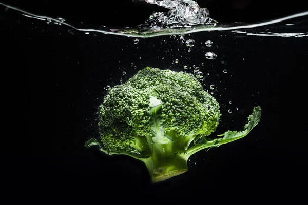 Свежий зеленый брокколи упал в воду изолированы — стоковое фото