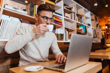 Kahve yudumlarken kafede oturan çekici adam