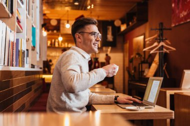 Kahve yudumlarken kafede oturan genç yakışıklı adam