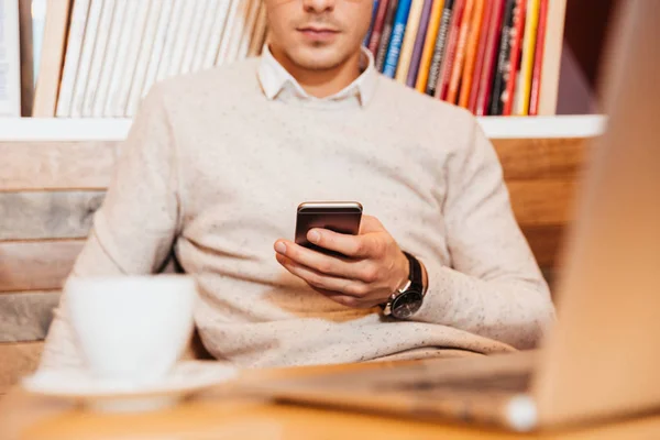 Обрезанное изображение молодого привлекательного мужчины с помощью мобильного телефона — стоковое фото