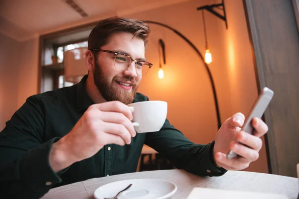 Retrato de un joven barbudo sonriente tomando café — Foto de Stock