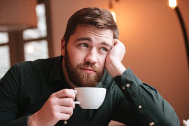 Sad genç adam kahve içme sakallı.