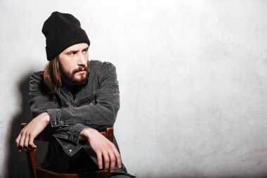 Sandalyede oturan şapkalı adam