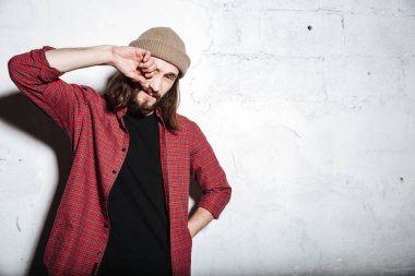 Çekici genç sakallı hippi adam duvar arka plan.