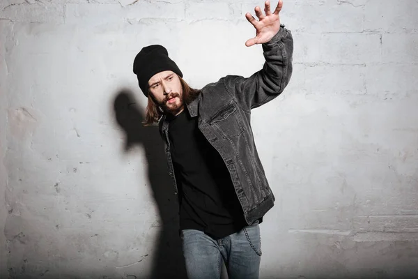 Retrato de un tipo hipster posando con la mano levantada —  Fotos de Stock