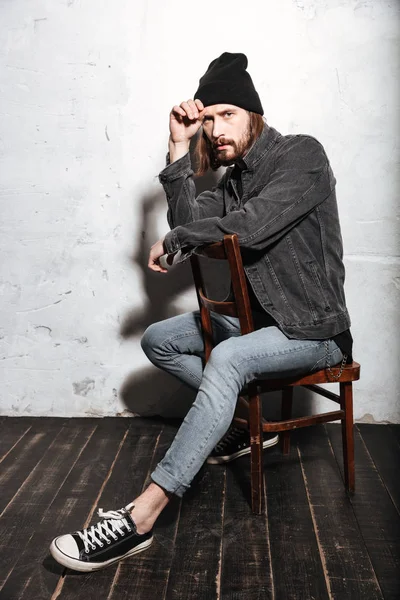 Retrato de un hombre hipster con sombrero sentado en la silla —  Fotos de Stock